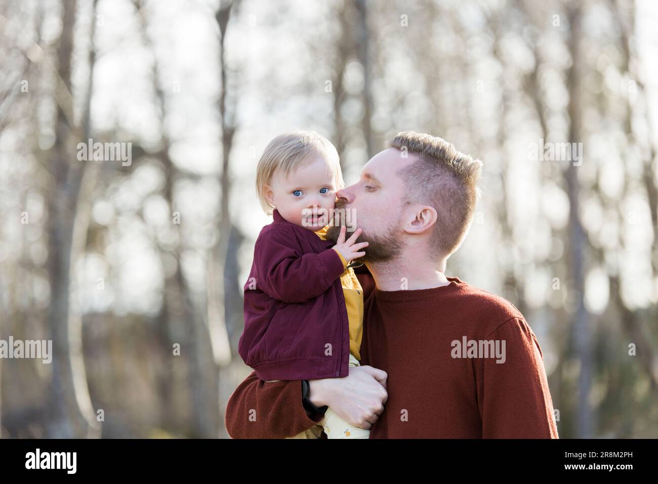 Vater gibt Baby mit Down-Syndrom einen Kuss auf die Wange Stockfoto