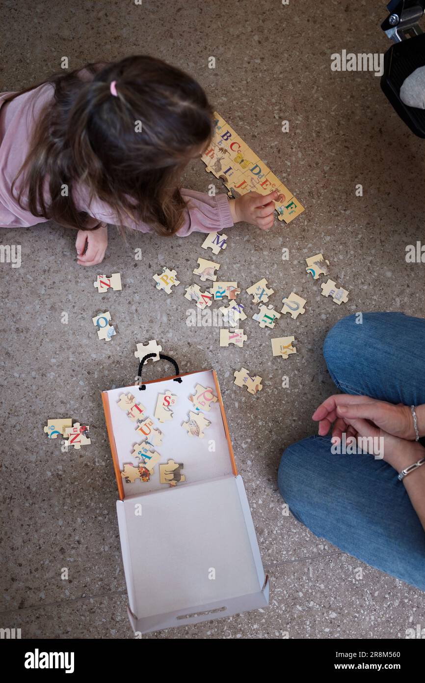 Ein Mädchen, das auf dem Boden liegt und Puzzles macht Stockfoto