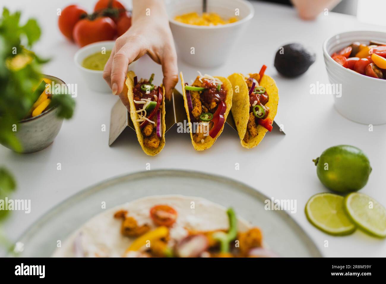 Person, die mexikanischen Taco vom Tablett nimmt Stockfoto