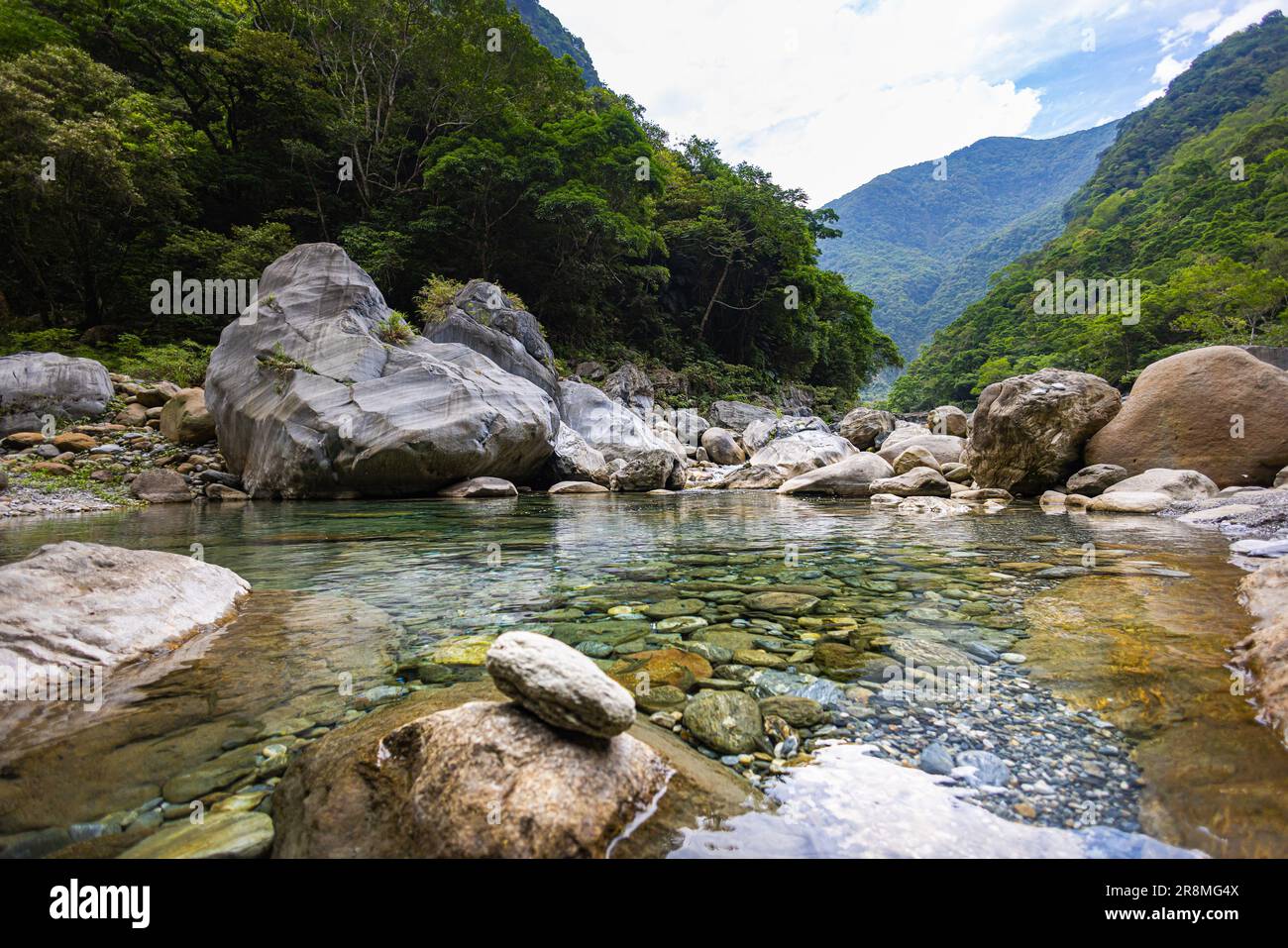 Idyllisches Foto eines Flusses, der sich durch das Tal des Taroko-Nationalparks schlängelt. Seidiges Wasser fließt über große Steine und schafft eine ruhige Atmosphäre. Im Shak Stockfoto