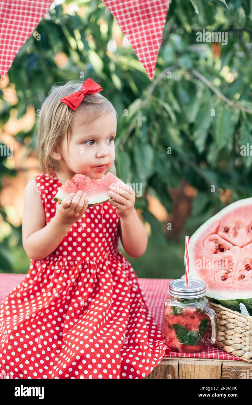 Süßes Kind isst im Sommer reife, saftige Wassermelone. Kind, Baby ...