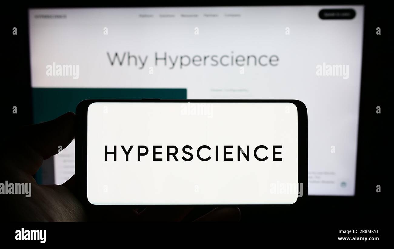 Person, die ein Mobiltelefon mit dem Logo des amerikanischen Unternehmens Hyper Labs Inc. Hält (Hyperscience) auf dem Bildschirm vor der Webseite. Konzentrieren Sie sich auf das Display des Telefons. Stockfoto