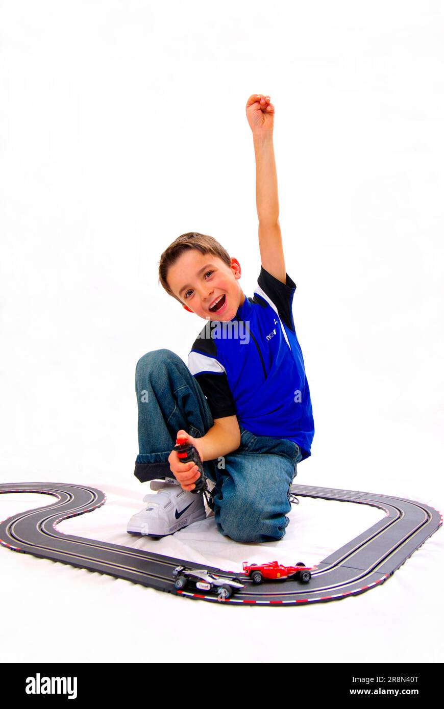 Junge mit Rennstrecke, Daumen hoch, Daumen hoch, Handzeichen, Spielzeug, Spiel, carrera-Titel Stockfoto