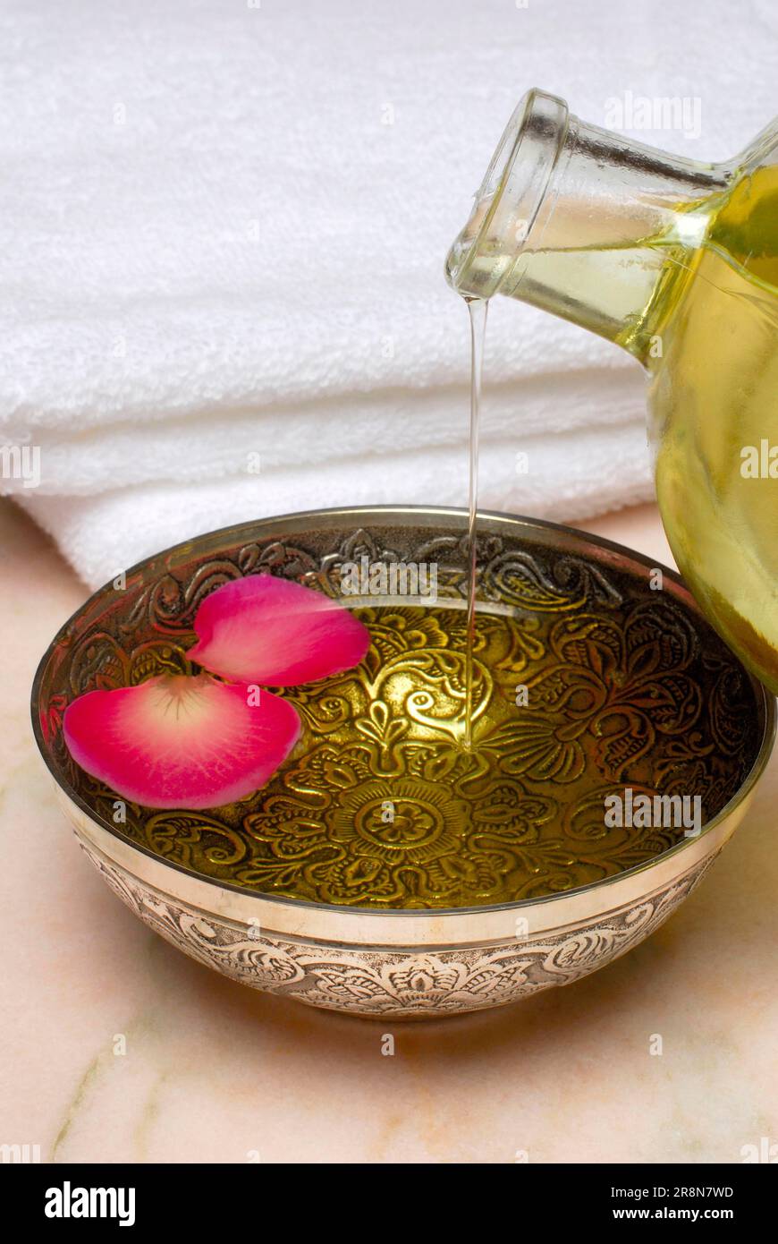 Schüssel mit Massageöl und Rosenblüten, Massageöl, Rosenblüten, Öl, Rosenblüten Stockfoto