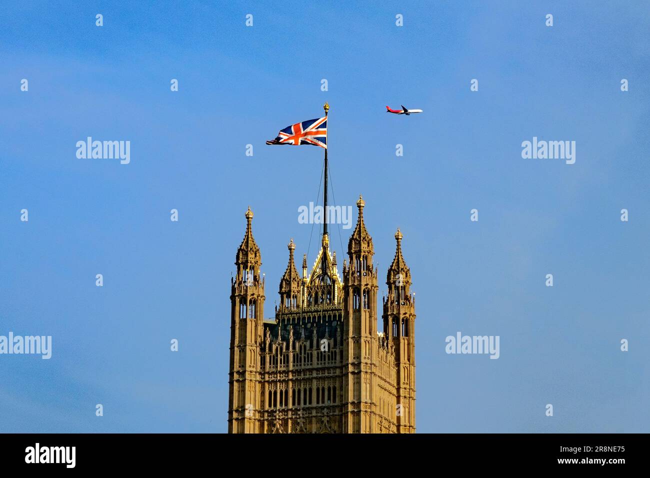 Ein Passagierflugzeug von Shenzhen Airlines ist abgebildet, wenn es über dem Victoria Tower des Palastes von Westminster fliegt. London 21. Juni 2023 Stockfoto