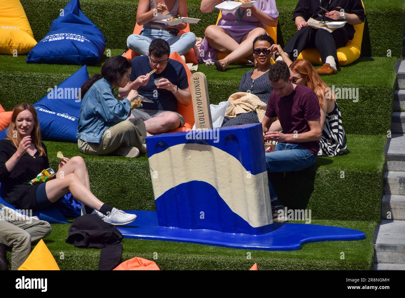 London, England, Großbritannien. 22. Juni 2023. Menschenmassen genießen die Sonne neben riesigen „Schmelzeis Lollies“ auf dem künstlichen Gras am Granary Square, King's Cross, während die Temperaturen in der Hauptstadt in die Höhe schnellen. (Kreditbild: © Vuk Valcic/ZUMA Press Wire) NUR REDAKTIONELLE VERWENDUNG! Nicht für den kommerziellen GEBRAUCH! Stockfoto