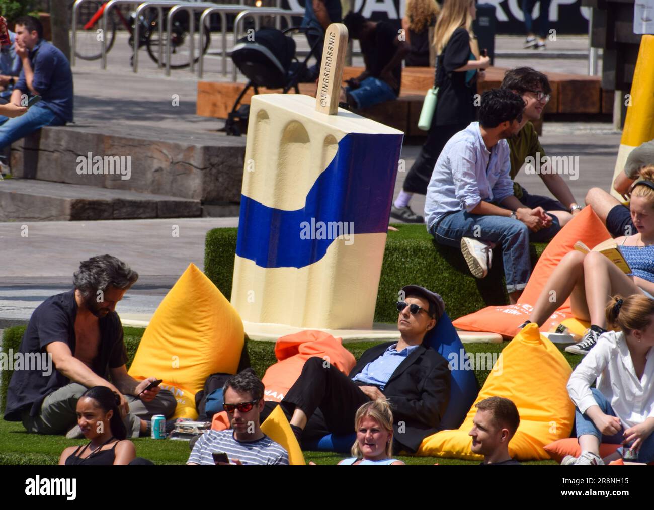 London, England, Großbritannien. 22. Juni 2023. Menschenmassen genießen die Sonne neben riesigen „Schmelzeis Lollies“ auf dem künstlichen Gras am Granary Square, King's Cross, während die Temperaturen in der Hauptstadt in die Höhe schnellen. (Kreditbild: © Vuk Valcic/ZUMA Press Wire) NUR REDAKTIONELLE VERWENDUNG! Nicht für den kommerziellen GEBRAUCH! Stockfoto