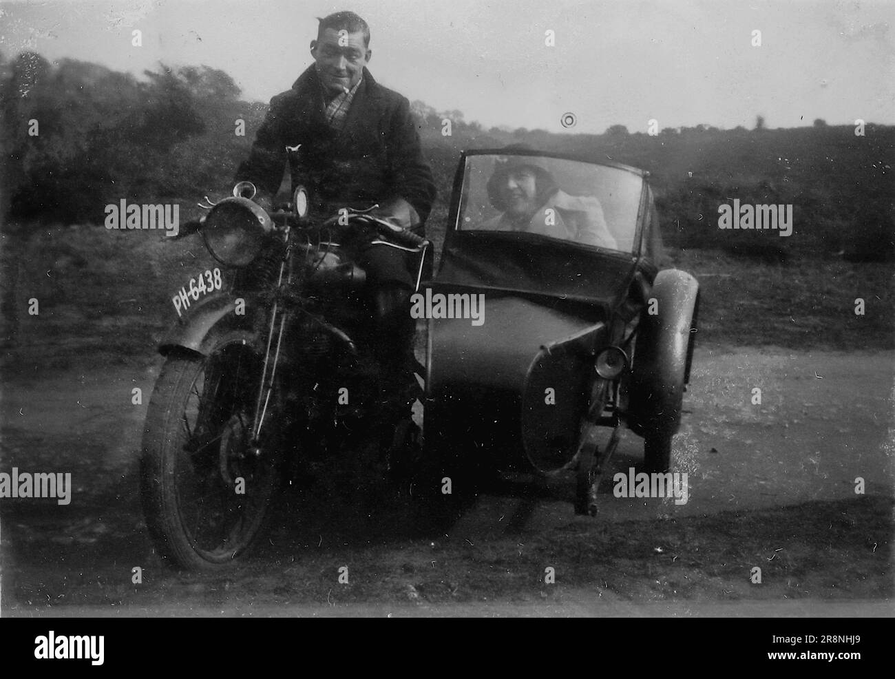 Snapshot, ein Mann auf einem Motorrad mit einer Begleiterin im Beiwagen, c1920er. Aus einer Sammlung von persönlichen Fotos, von denen viele nicht detailliert kommentiert wurden. Die unbenannte Familie stammt aus Witley, einem kleinen Dorf in Waverley und in der Nähe von Godalming in Surrey, England. Stockfoto