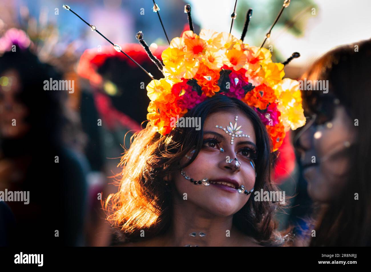 Eine junge Mexikanerin mit Gesichtsschmuck und Blumenkopf nimmt an den Feierlichkeiten zum Todestag in Morelia, Michoacán, Mexiko Teil. Stockfoto