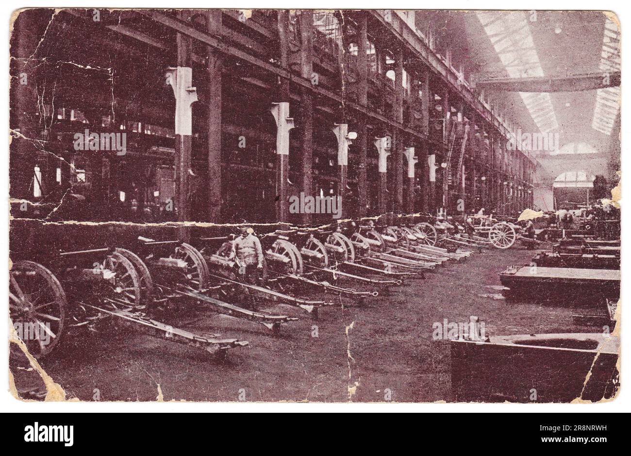 Vintage-Postkarte mit verwitterten Rändern auf weißem Hintergrund, bedruckt um 1916. Werkstatt für die Herstellung von Artilleriestücken der Putilov-Fabrik. Stockfoto