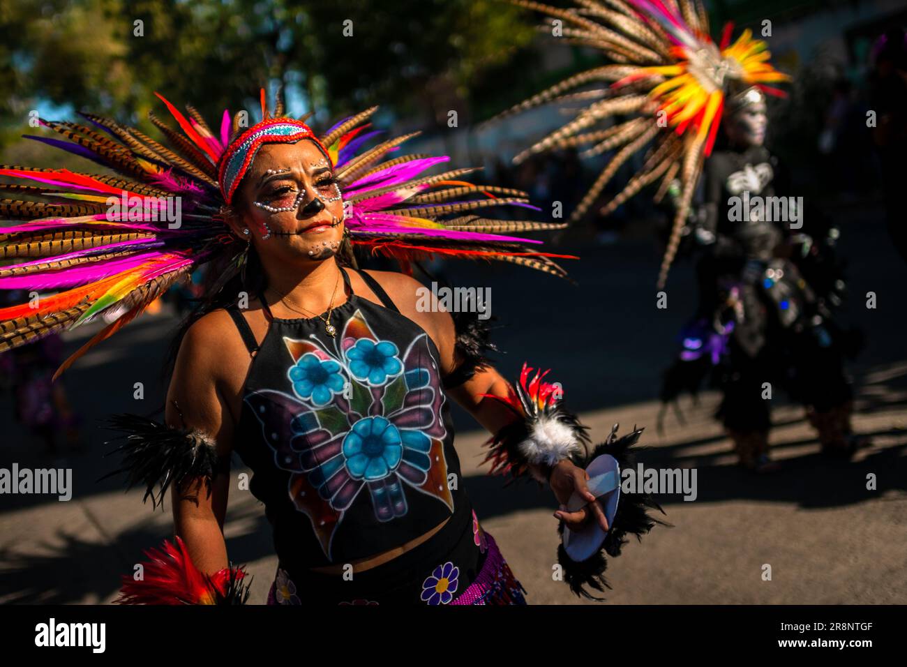 Eine junge Mexikanerin trägt einen Azteken-Federkopfschmuck und führt während der Day of the Dead-Feierlichkeiten in Guadalajara, Jalisco, Mexiko, eine Tanznummer auf. Stockfoto