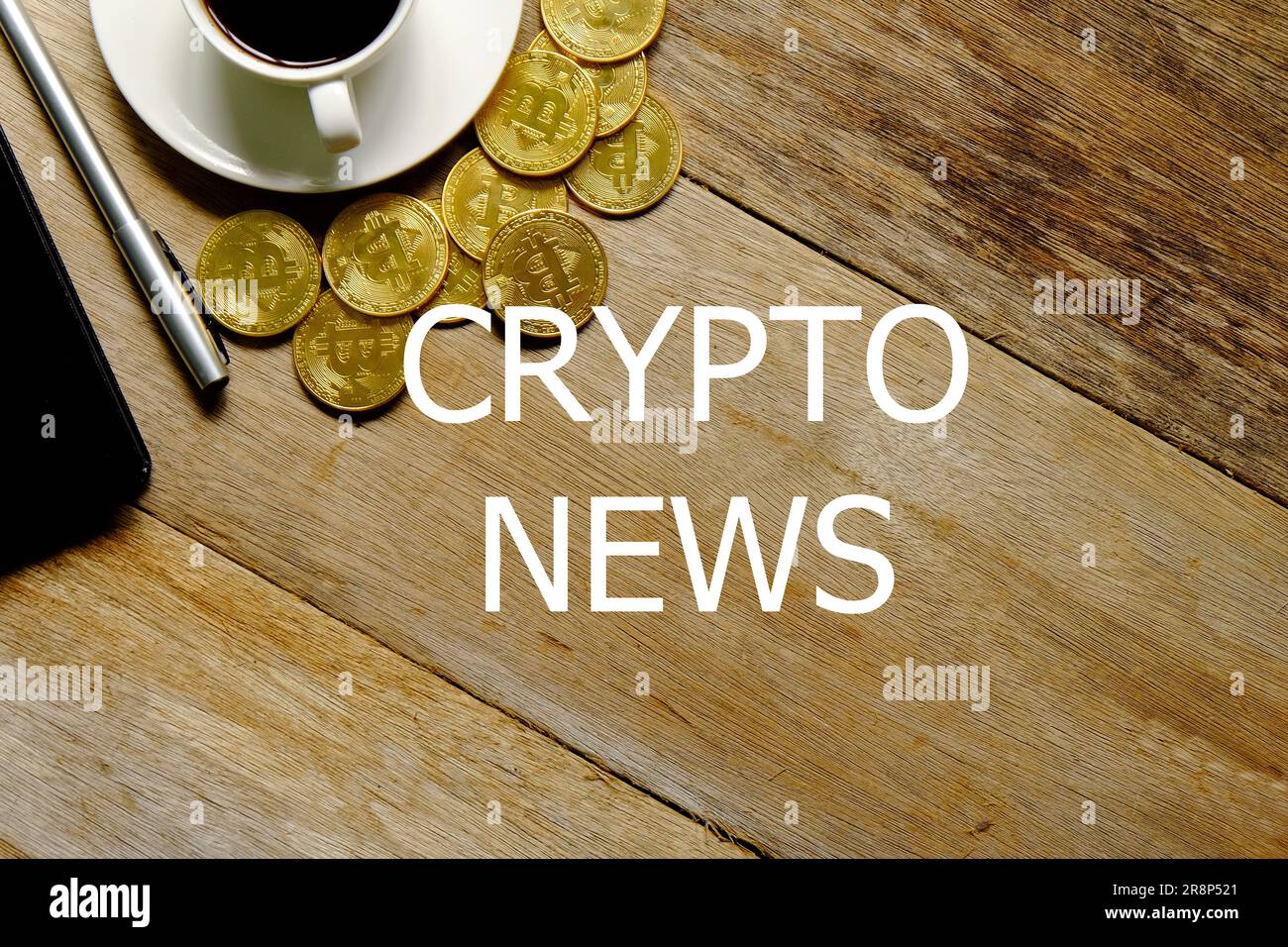 Blick von oben auf eine Tasse Kaffee, goldene Bitcoin Replica, Notizbuch und Stift auf Holzhintergrund geschrieben mit CRYPTO NEWS. Stockfoto