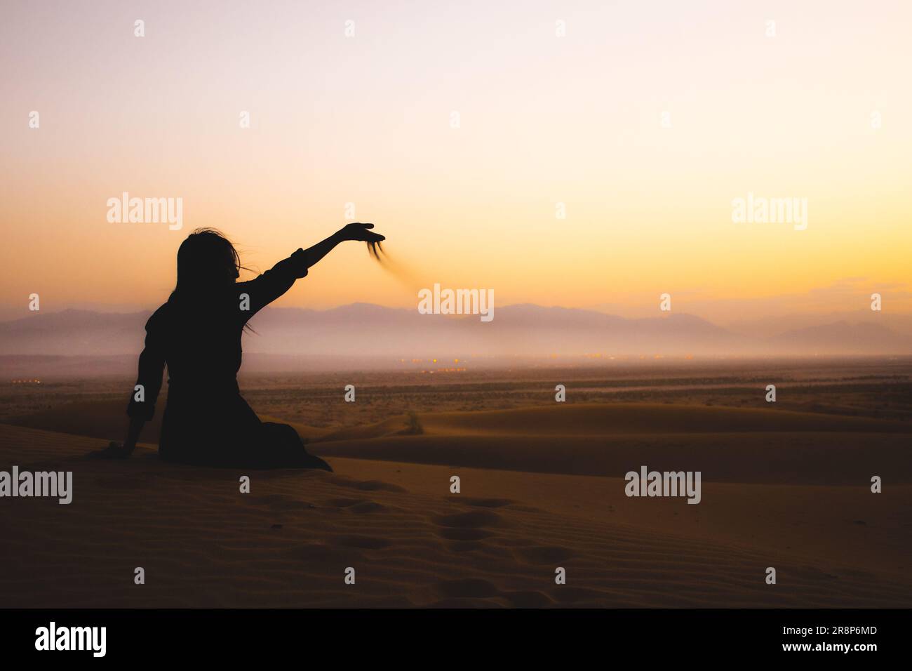 Junge, wunderschöne Frau Gießen Sand Spiel mit Sanddünen Hand Genießen Sie Freiheit Reise Abenteuer in der iran Kashan Wüste Stockfoto