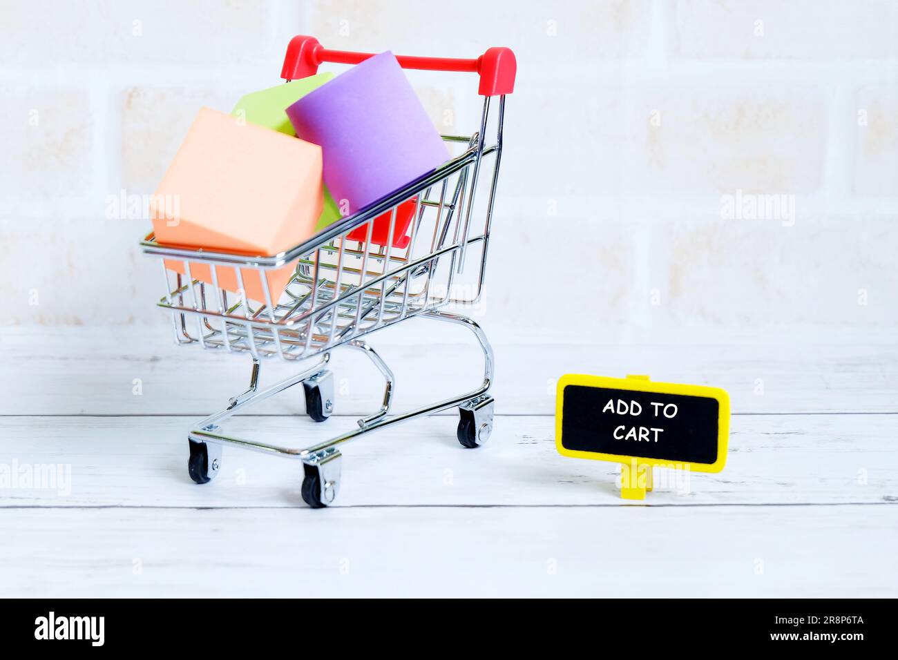 Selektiver Fokus auf Warenkorb oder Einkaufswagen mit gelber Tafel mit der Aufschrift „IN WARENKORB“. Shopping-Thema. Stockfoto