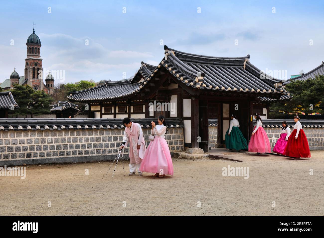 JEONJU, SÜDKOREA - 4. APRIL 2023: Touristen in traditioneller koreanischer hanbok-Kleidung besuchen den Gyeonggijeon-Schrein in Jeonju. Stockfoto
