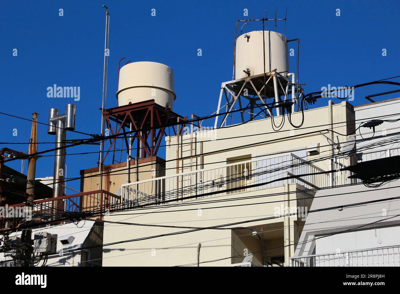 Wasserdruckbehälter auf dem Dach in Tokio, Japan. Versorgungsinfrastruktur in Japan. Stockfoto