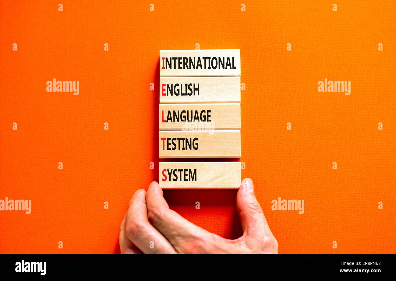 IELTS-Symbol. Konzeptbegriffe IELTS internationales englischsprachiges Prüfsystem auf Holzblock. Wunderschöner orangefarbener Hintergrund. Business IELTS internati Stockfoto