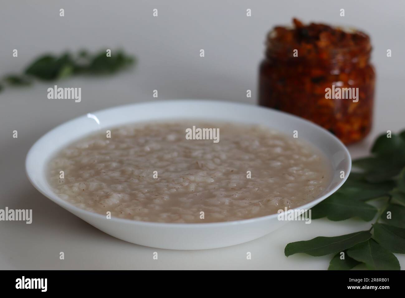 Kanji und Kadumanga. Reismehl mit Kerala Matta Reis. Aufgenommen mit Kerala-Mango-Gurke auf weißem Hintergrund. Stockfoto