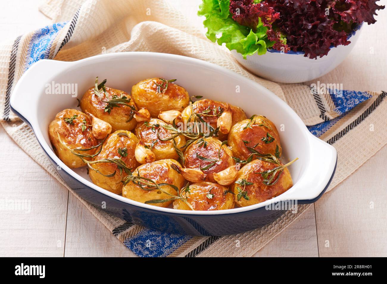 Geröstete Kartoffeln mit Knoblauch, Thymian und Rosmarin in Keramikform Stockfoto