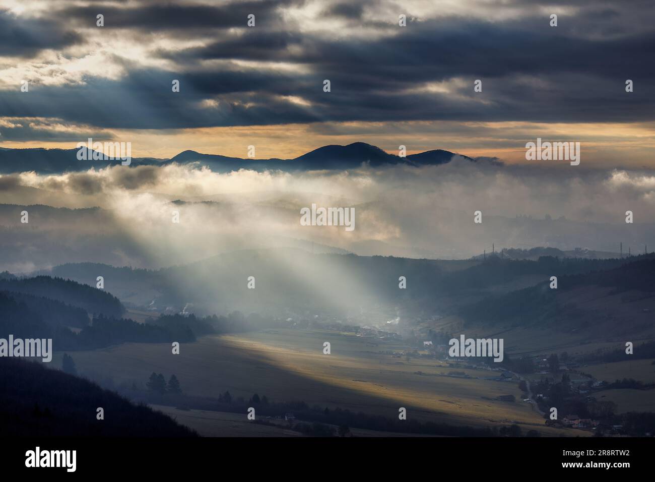 Bergige Landschaft mit nebligen Tälern bei dramatischem Licht bei Sonnenuntergang. Nordwest-Slowakei, Europa. Stockfoto