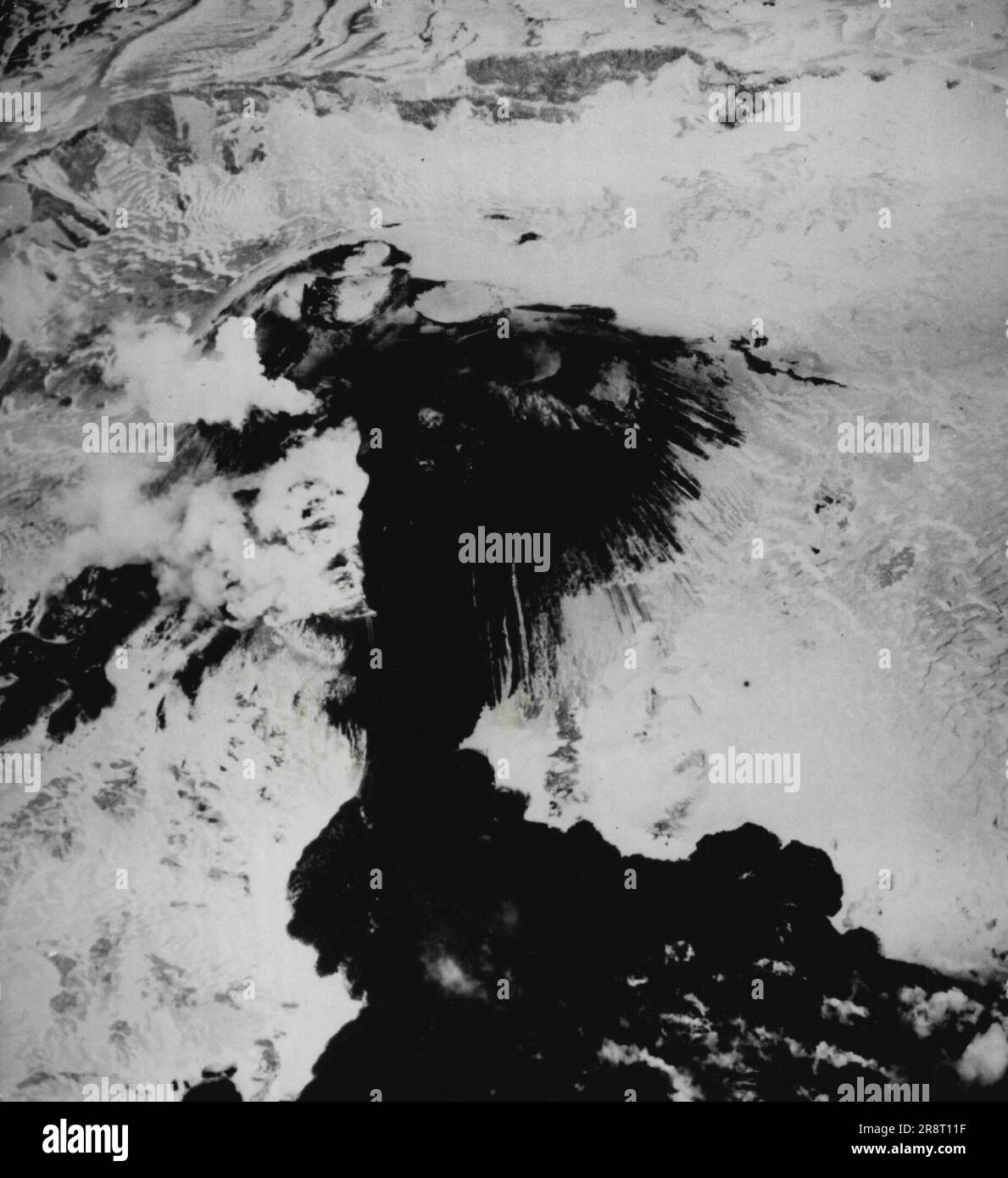 Lavasee geformt auf Gletschereis -- dieser Lavasee (unten) entstand auf dem Eis eines Gletschers an der Seite des ausbrechenden Akutan Peak auf den Aleuten Inseln. Beachten Sie Krater und rauchende Lava auf diesem Foto, das von einem Navy-Fotografen gemacht wurde, der fast über Ihnen fliegt. 01. Dezember 1947. (Foto nach zugehörigem Pressefoto). Stockfoto