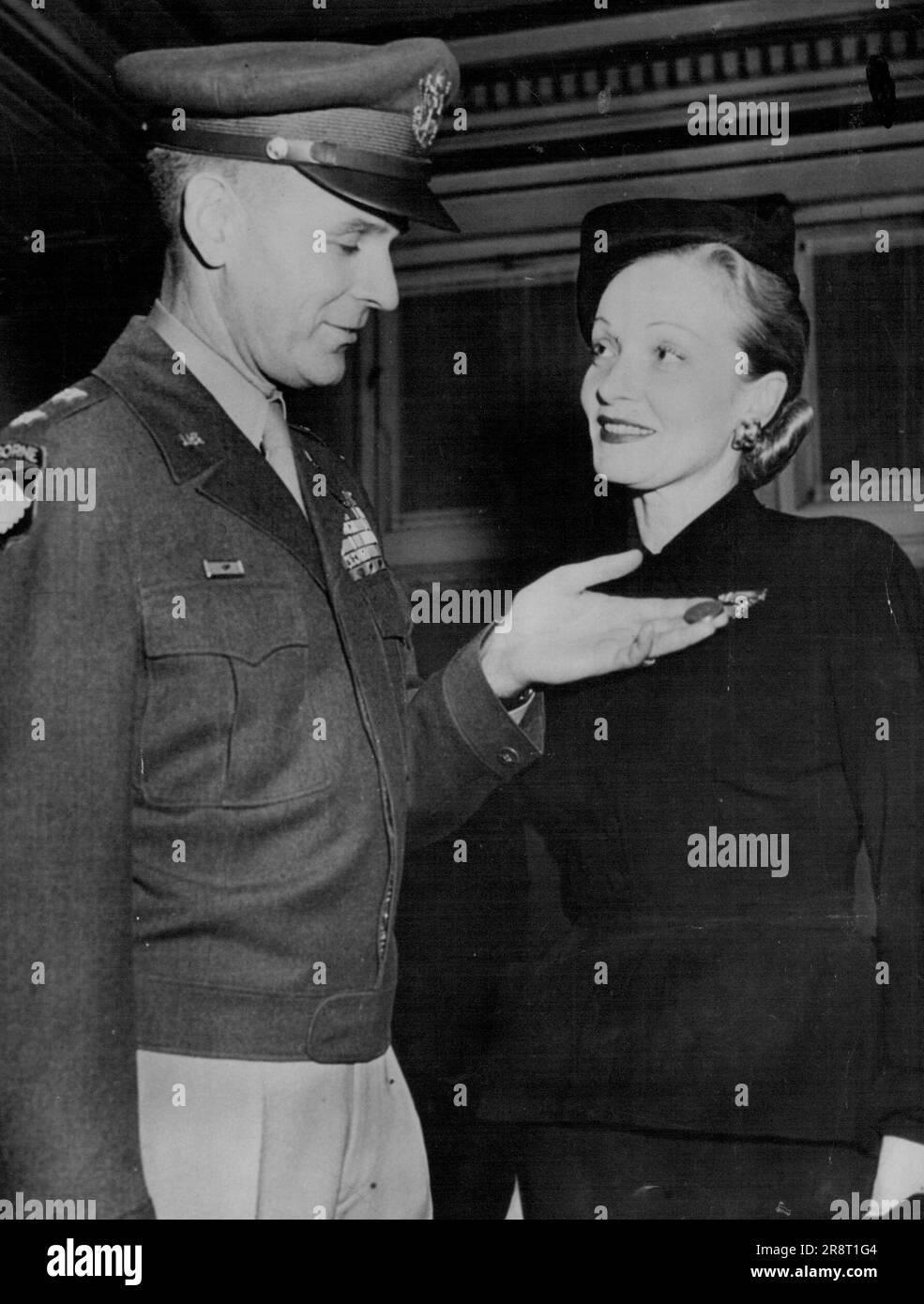 Marlene für Kriegsarbeit geehrt... Schauspielerin Marlene Dietrich lächelt als Major General Maxwell D. Taylor, Superintendent der USA Militärakademie in West Point, bewundert die Medaille für Freiheit, die er ihr für ihre Arbeit angeheftet hat, als sie während des Krieges Truppen in Übersee unterhielt. Die Preisverleihung fand am 18. November in der Cullum Memorial Hall in West Point statt. 19. November 1947. (Foto nach zugehörigem Pressefoto). Stockfoto