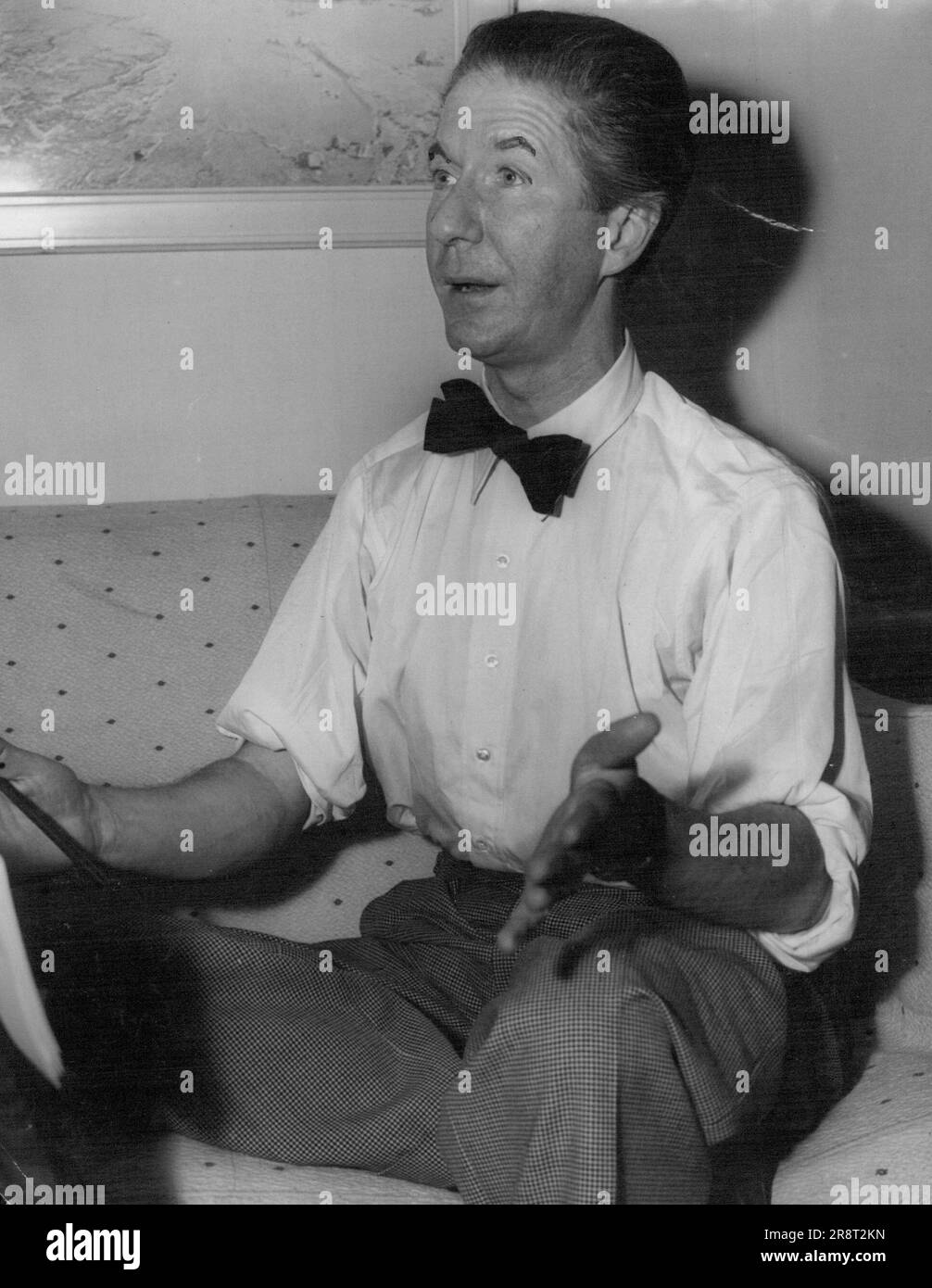 Ein gut gekleidetes Publikum von 200 Frauen hat gestern Abend an einer Hütenparade teilgenommen, die von Royal Milliner Aage Thaarup gezeigt wurde. Nur wenige Männer waren anwesend. Die Parade fand in David Jones' Art Gallery statt. Cocktails wurden serviert, bevor es anfing. Die einzige Dekoration waren rosarote Vorhänge, die auf der Bühne hängen. Aage Thaarup bevorzugt keine Einrichtung bei seinen Paraden, da er glaubt, dass die Aufmerksamkeit des Publikums nicht von seinen Hüten abgelenkt werden sollte. Er beschrieb jeden seiner Hüte so, wie er von den Schaufensterpuppen gezeigt wurde. 17. Februar 1952. Stockfoto