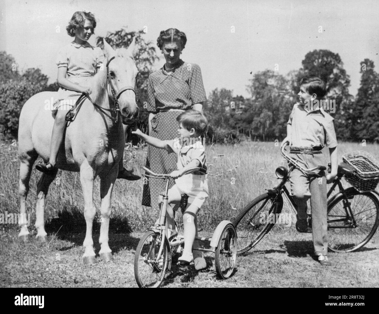 Royal Family Relaxes - der Herzog von Kent (Extreme Right), der im Oktober 9 zehn Jahre alt war und hier vor kurzem mit seiner Mutter H.R.H. gesehen wurde Die Herzogin von Kent, Prinzessin Alexandra (auf dem Pferderücken) und Prinz Michael (auf dem Dreirad) in ihrem Landhaus Coppins, Iver, Buckinghamshire. 17. Oktober 1945. (Foto nach zugehörigem Pressefoto). Stockfoto