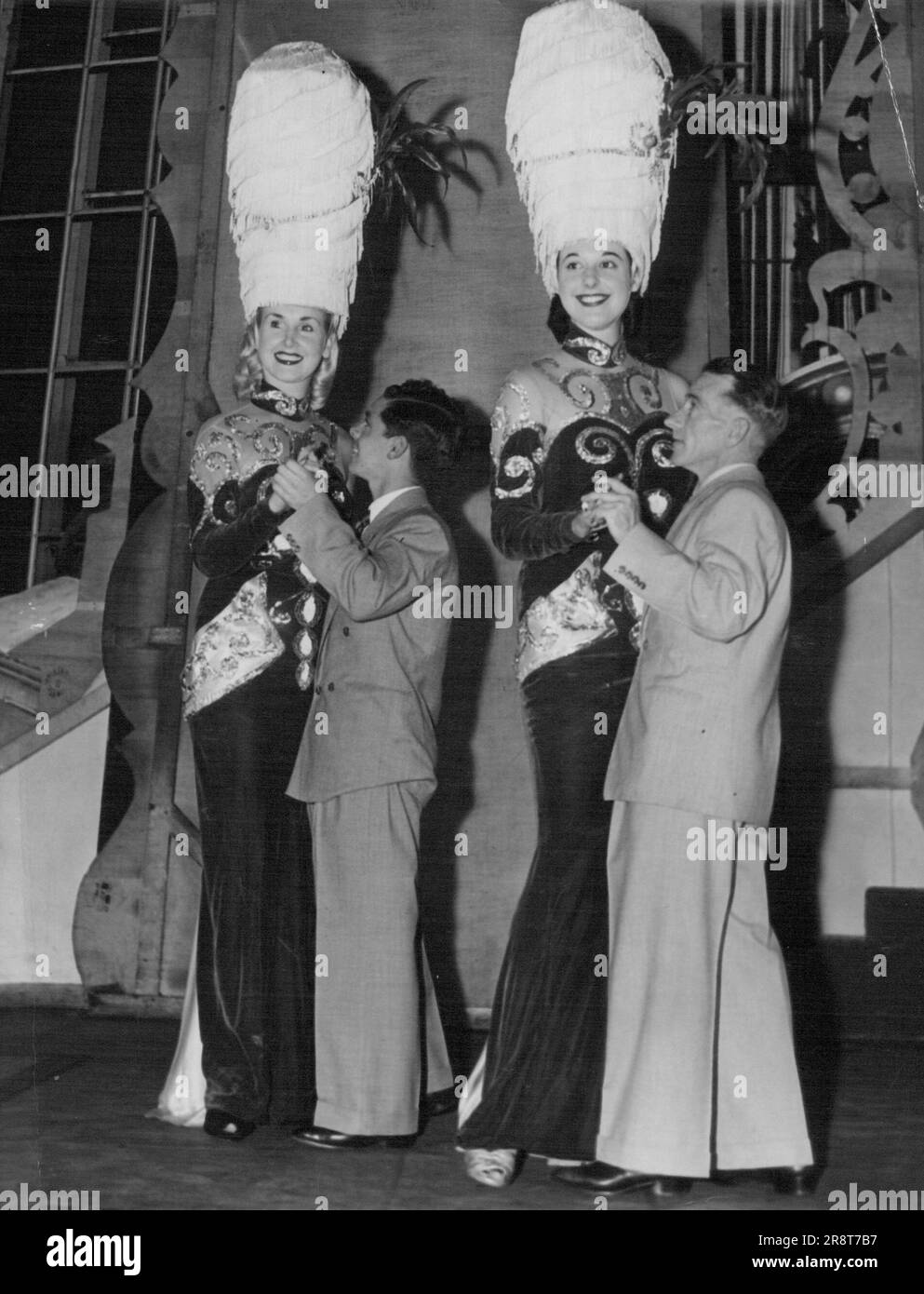 „Hallo – Da Oben!“ Die Jockeys Ray Selkrig und Arthur Podmore werden es nächste Woche nicht leicht haben, wenn sie das Walzer Derby mit Folies Bergere Showgirls, Joy Gibbs und Dionne Vail tanzen. Unser Kameramann fand gestern eine ruhige Probefahrt vor, und es war keine Wange-an-Wange-Affäre. Der Ball, der nächsten Mittwoch im Trocadero stattfindet, wird den Schauspielern und Ausbildern helfen. 02. Oktober 1952. Stockfoto