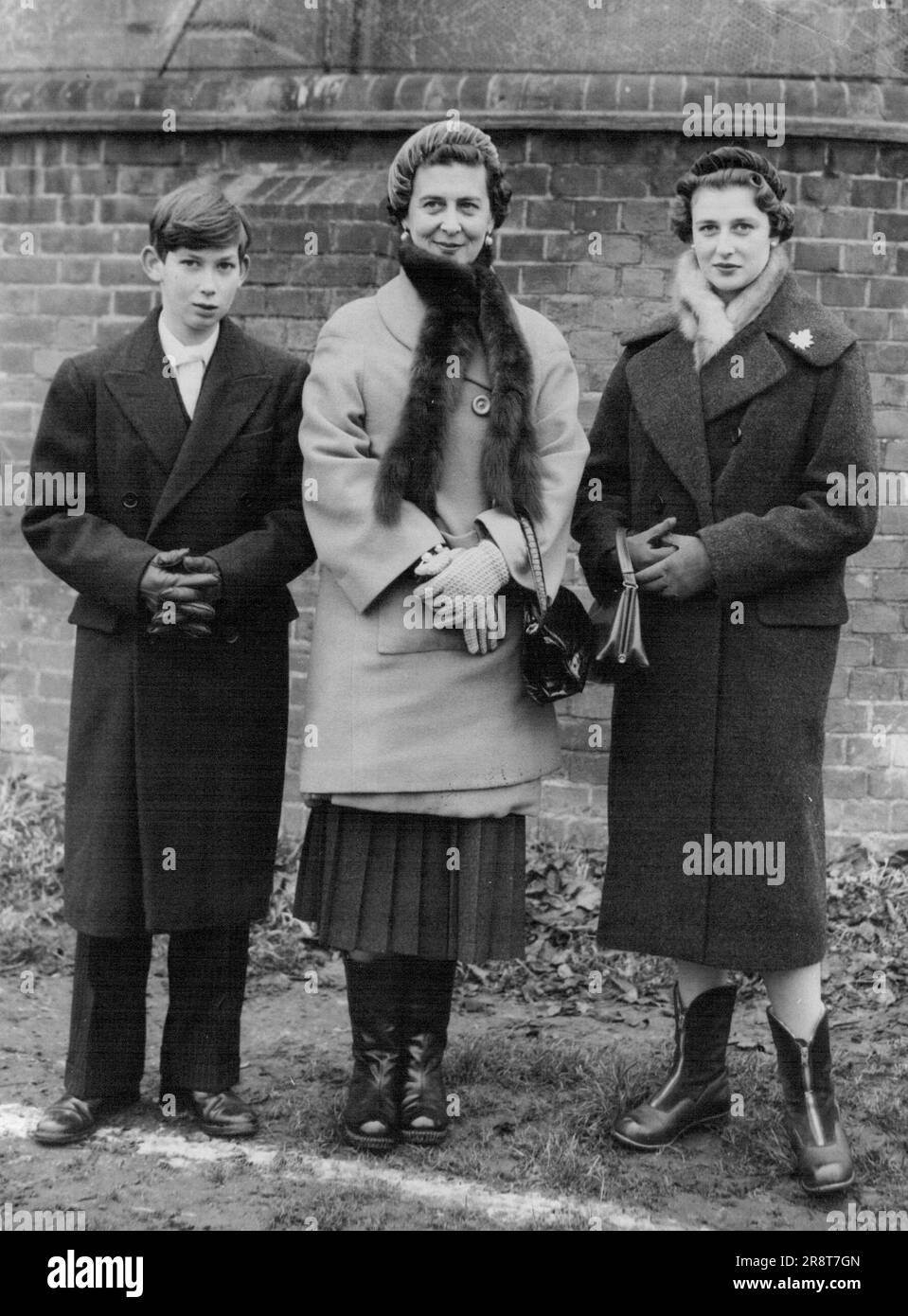 Prinz Michael bekommt einen Besuch in Eton von seiner Mutter und Schwester -- warm gekleidet gegen das kalte Wetter und in hohen Stiefeln, die Herzogin von Kent und ihre 18-jährige Tochter Prinzessin Alexandra werden mit dem jüngeren Sohn der Herzogin, Prinz Michael, im Alter von 13 Jahren, abgebildet, als sie ihm einen St. bezahlten Andrew's Day Besuch am Eton College, Buckinghamshire, bis Mittwoch. Die königlichen Besucher sahen das traditionelle Wall Game zwischen Collegers und oppidans. Prinz Michael ist in seiner ersten Hälfte in Eton. 30. November 1955. (Foto von Reuterphoto). Stockfoto