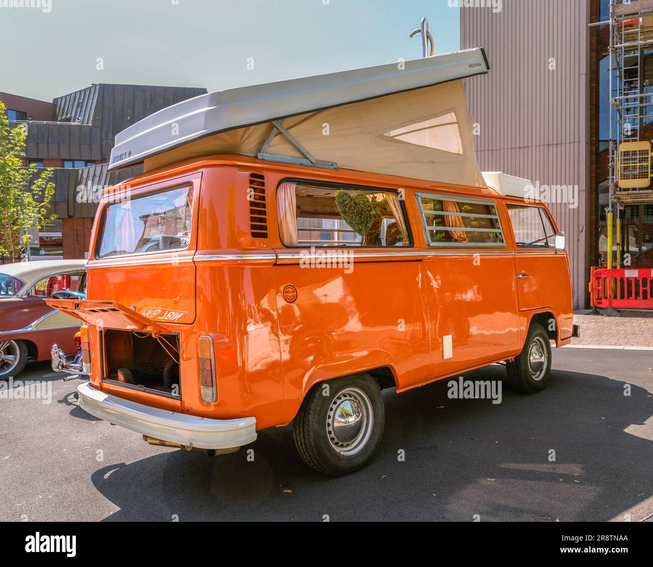 Ein orangefarbener Volkswagen-Wohnwagen aus den 1970er Jahren mit hochgeklapptem Dach. VW-Wohnmobil auf der Oldtimer- und Oldtimer-Ausstellung. Stockfoto