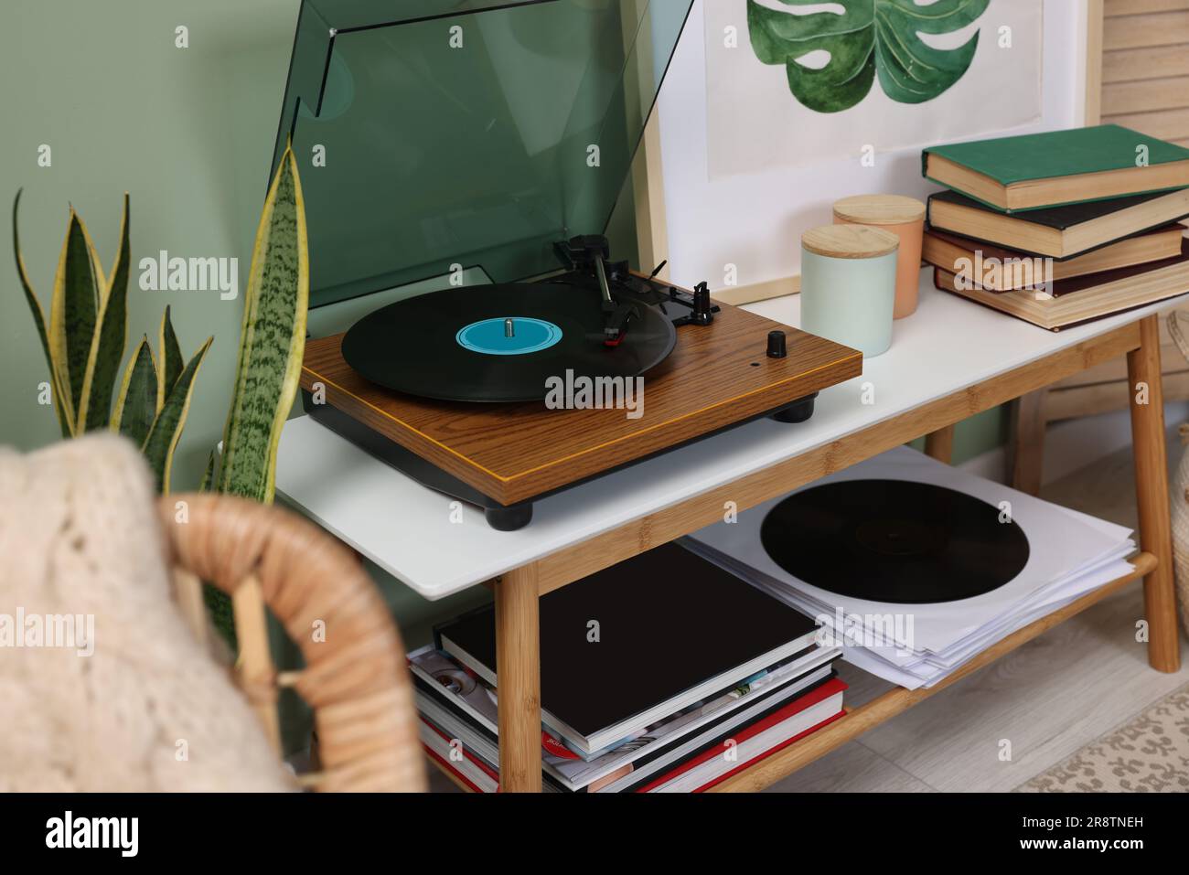 Eleganter Plattenspieler mit Schallplatte auf dem Konsolentisch im Zimmer Stockfoto