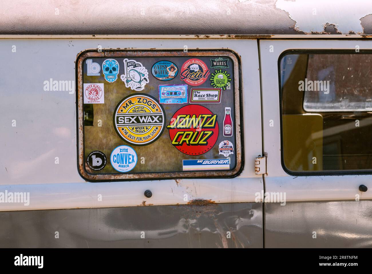 Detail des aufgeklebten Fensters eines weit gereisten und rostigen VW-Wohnwagens. Roadtrip, böhmischer Lifestyle oder Camping-Konzept. Stockfoto