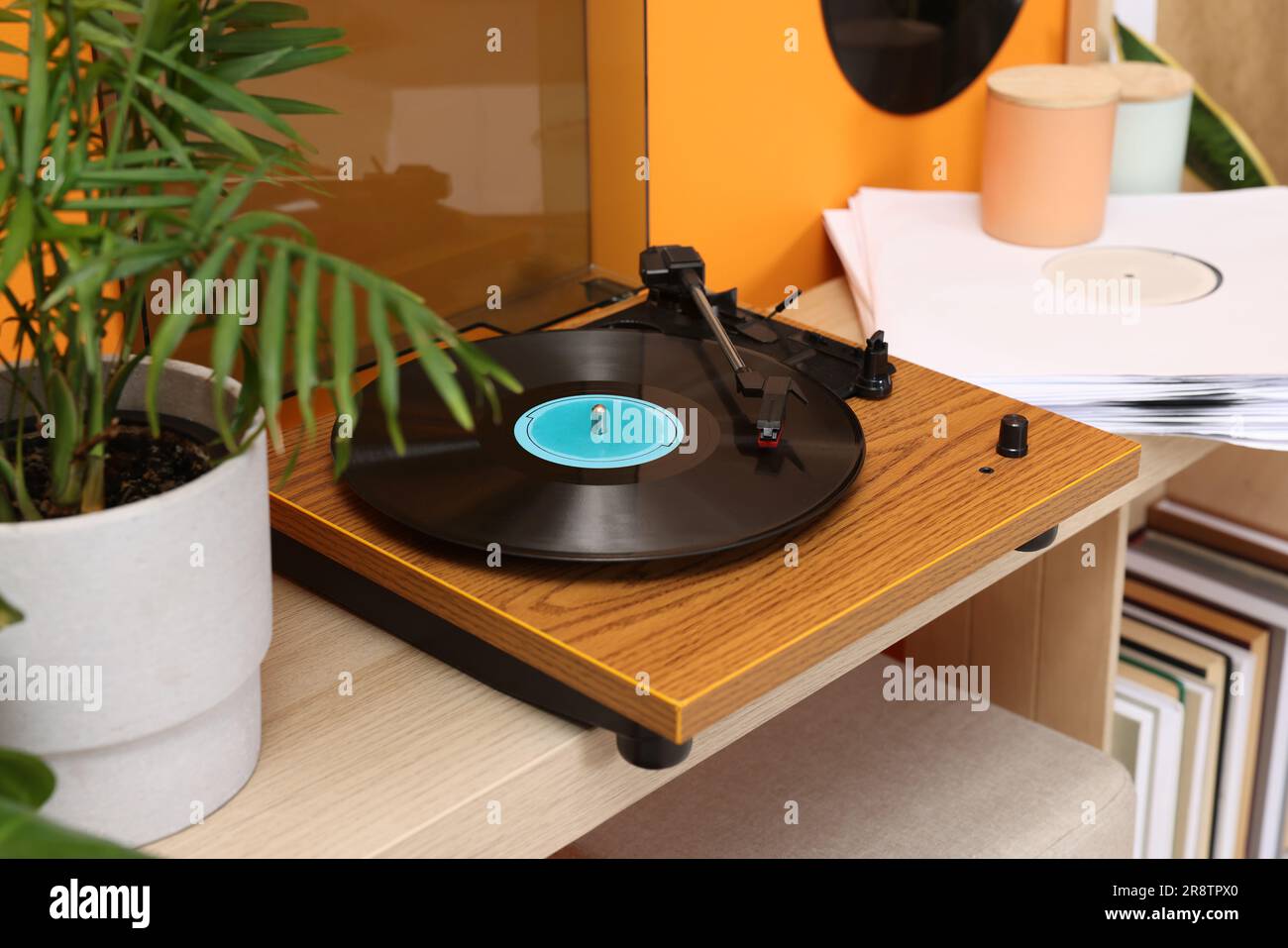 Eleganter Plattenspieler mit Vinylplatte auf dem Konsolentisch im Innenbereich Stockfoto