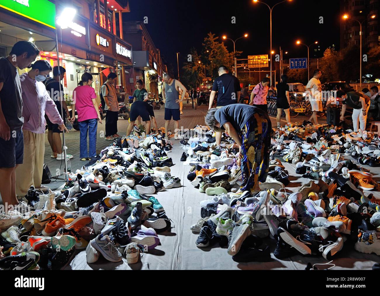 PEKING, CHINA - 22. JUNI 2023 - Bürger kaufen Aktienschuhe, die von Verkäufern auf einer Straße in Peking, China, am 22. Juni 2023 spät nachts verkauft werden. Stockfoto