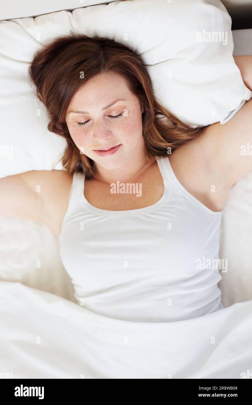 Schlafend, erholt und Frau im Bett von oben, friedlich und genießt ein ruhiges Nickerchen in ihrem Zuhause. Top Aussicht, träumend und weibliche Person in einem Schlafzimmer für Schlummerfunktion Stockfoto
