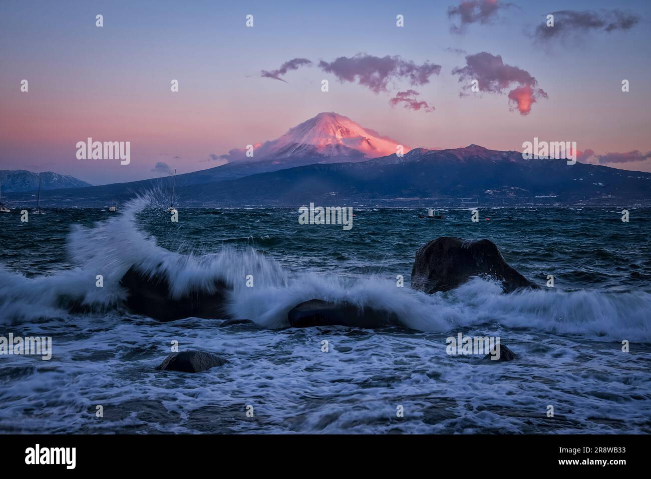 Große Wellen und Kurenai Fuji (Berg Fuji in Rot) mit Blick auf die Nordküste der Halbinsel Izu Stockfoto