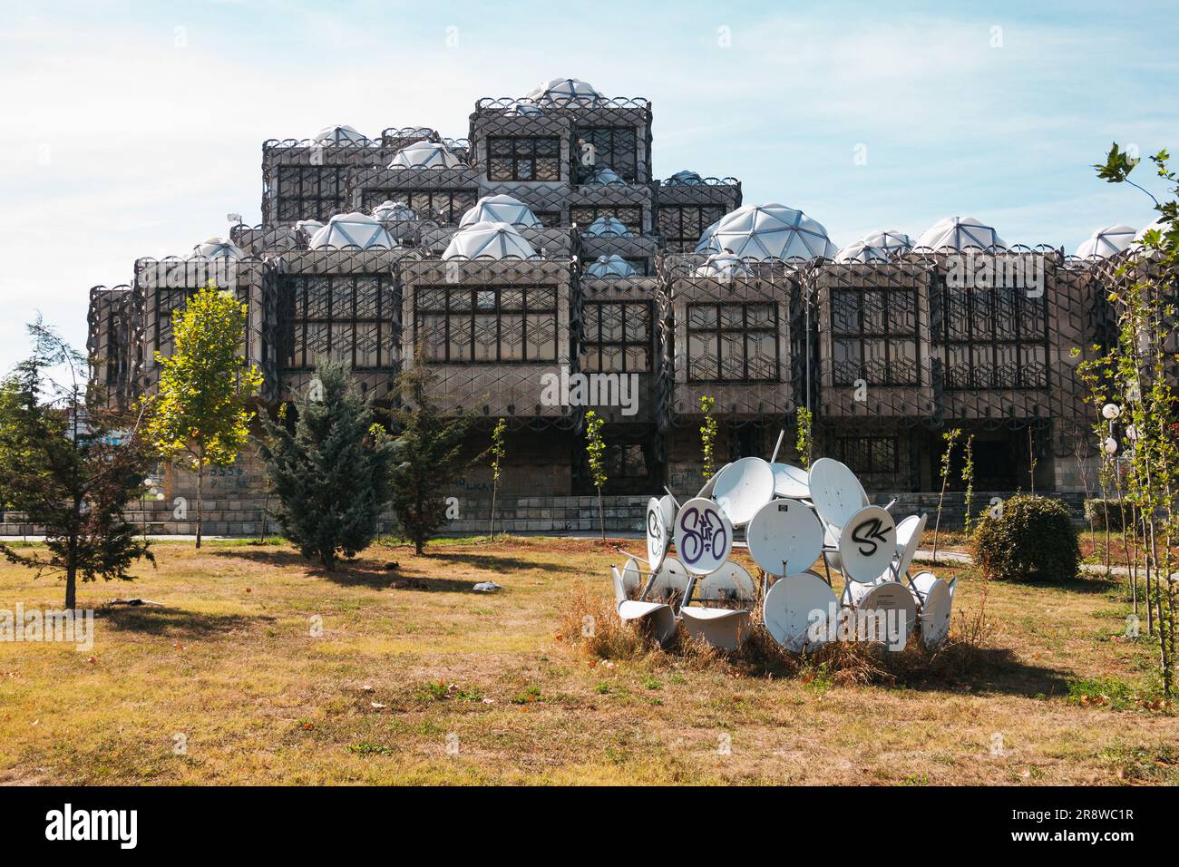 Satellitenschüsseln schaffen eine Kunstinstallation auf dem Gelände der ungewöhnlich aussehenden Nationalbibliothek des Kosovo, Pristina Stockfoto