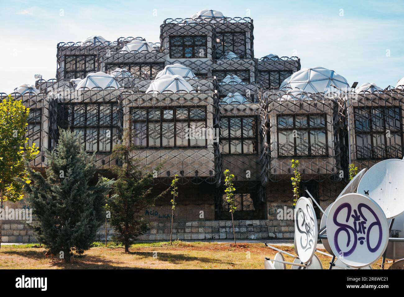Satellitenschüsseln schaffen eine Kunstinstallation auf dem Gelände der ungewöhnlich aussehenden Nationalbibliothek des Kosovo, Pristina Stockfoto