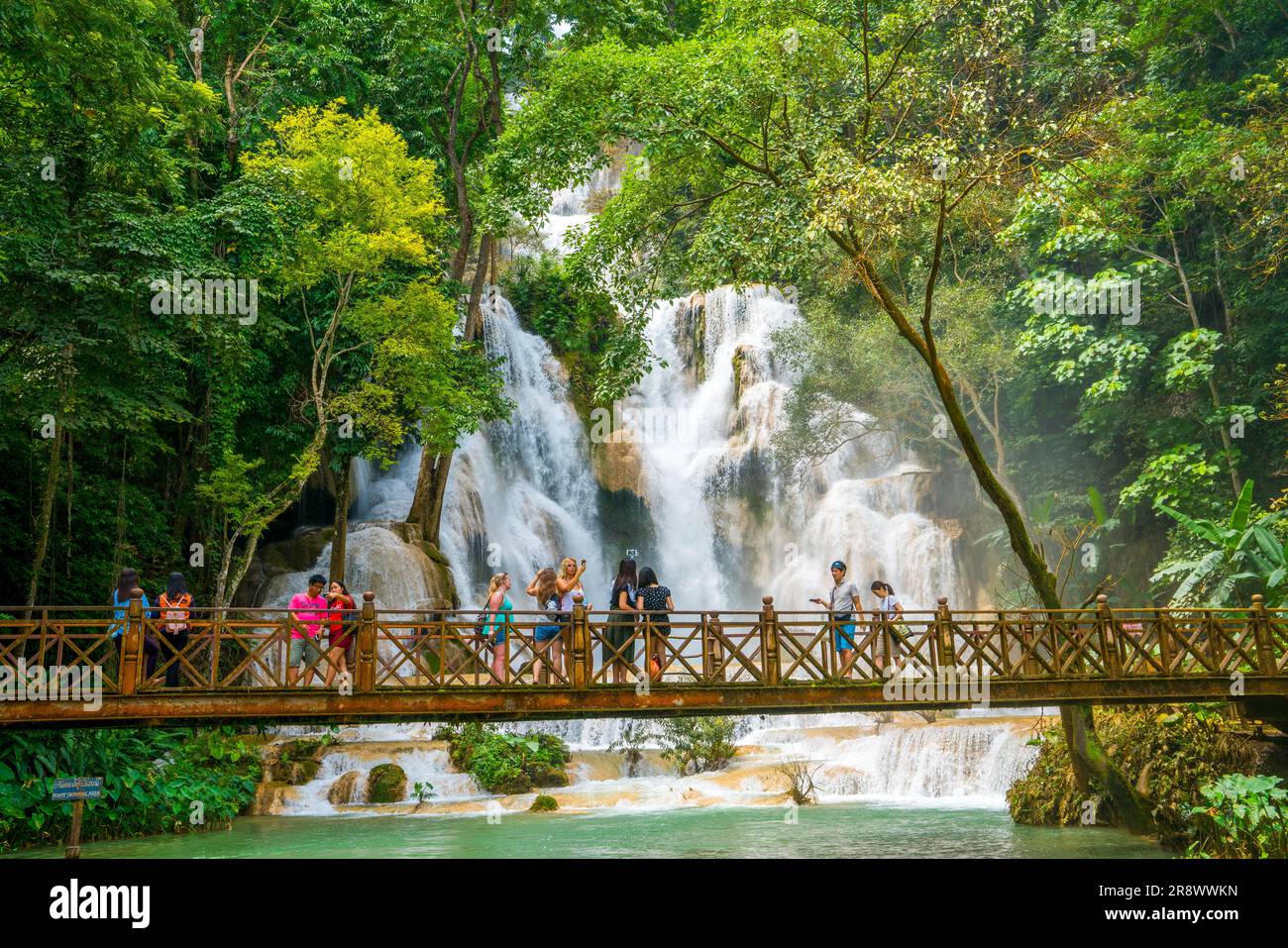 Touristen machen Selfies und Fotos von den Kuang Si Wasserfällen in der Nähe von Luang Prabang in Loas. Ein beliebter Touristenausflug mit tropischem Dschungel und türkisfarbenen Pools. Stockfoto
