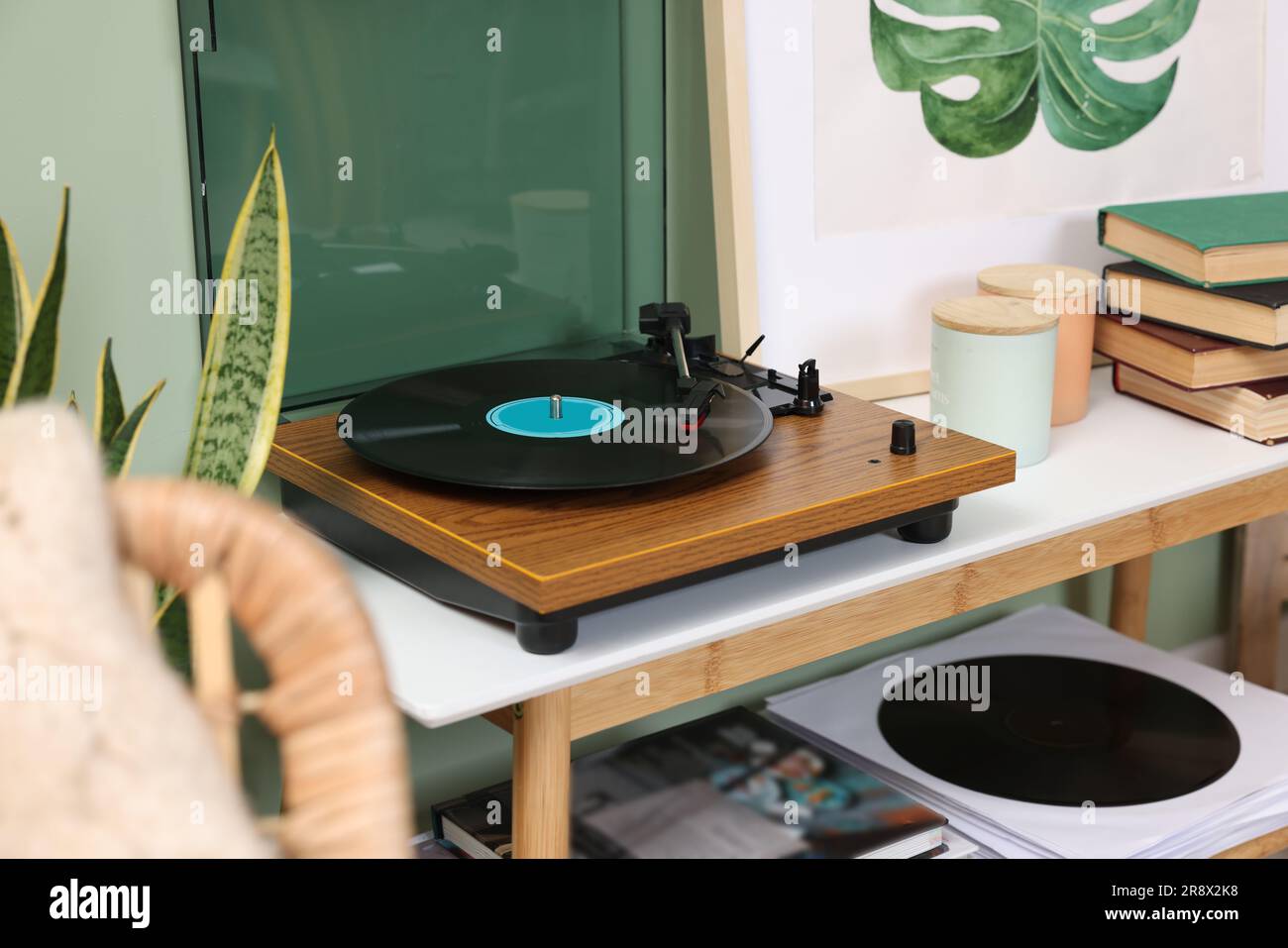 Eleganter Plattenspieler mit Schallplatte auf dem Konsolentisch im Zimmer Stockfoto