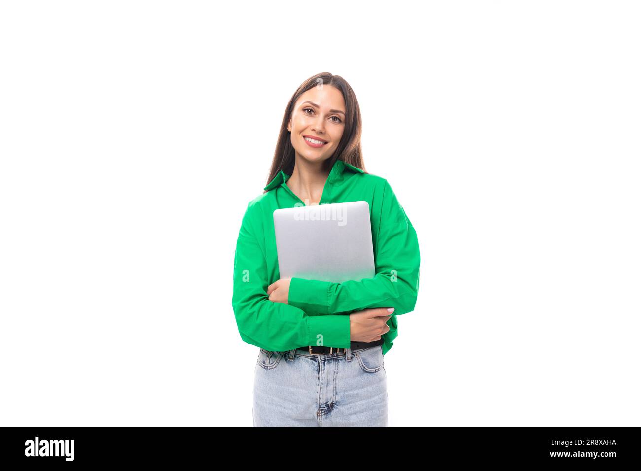 Süße junge, braunäugige, braunhaarige Karrierefrau mit Make-up in einer grünen Bluse arbeitet Remote im IT-Bereich Stockfoto