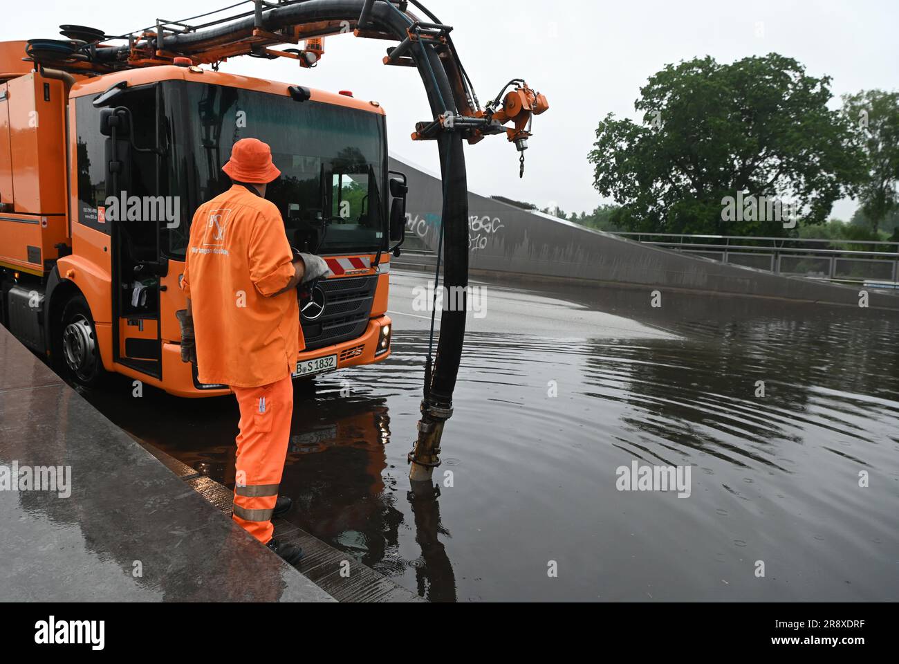 Berlin, Deutschland. 23. Juni 2023. Ein Pumpfahrzeug der Berliner Stadtreinigung BSR steht auf der überfluteten Freybrücke in der Heerstraße. Aufgrund der starken Regenfälle ist die Straße in der Gegend unpassierbar. Es ist für normalen Verkehr geschlossen. Es gibt erhebliche Verkehrsbehinderungen. Kredit: Paul Zinken/dpa/Alamy Live News Stockfoto