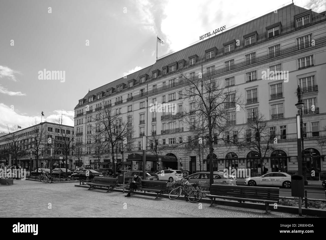 Berlin, Deutschland - 18. April 2023 : Blick auf das berühmte Adlon Hotel und die deutsche Nationalflagge in Berlin in Schwarz und Weiß Stockfoto