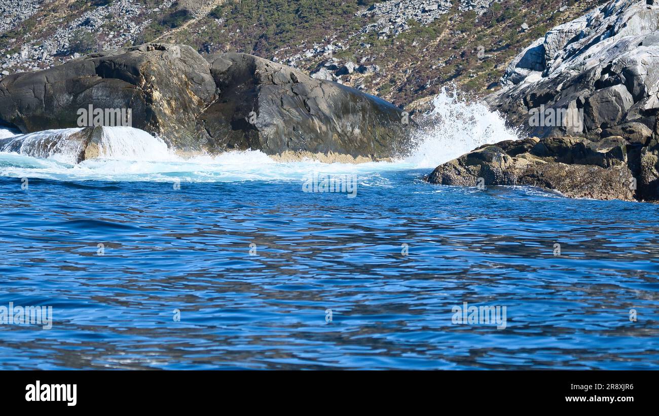 norwegen auf dem Fjord, auf Felsen sprühen. Wasser spritzt auf die Steine. Küstenlandschaft in Skandinavien. Landschaftsfoto aus dem Norden Stockfoto