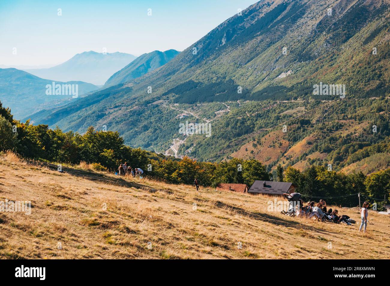 An einem sonnigen Sommerwochenende in Prevalla, einer Bergstadt im Kosovo, entspannen sich die Menschen auf den grasbedeckten Hängen des Prevalla Field Stockfoto