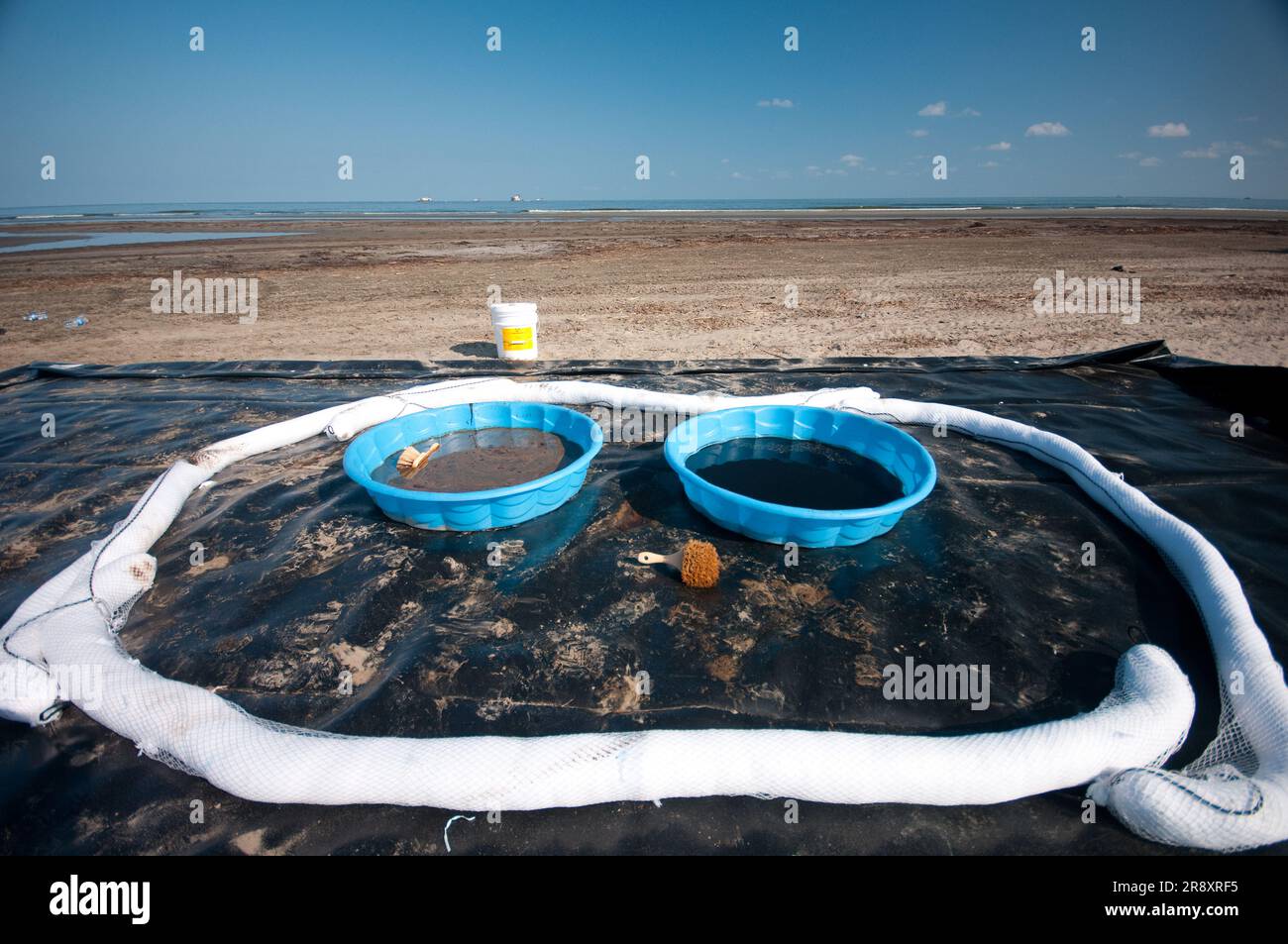 Dekontaminieren Sie Pools entlang des Strandes auf Grand Terre Island, in denen die Reinigungsteams am Ende jedes Tages ihre Stiefel abwaschen. Die waren für die Nacht am Ende einer Scherbe Stockfoto