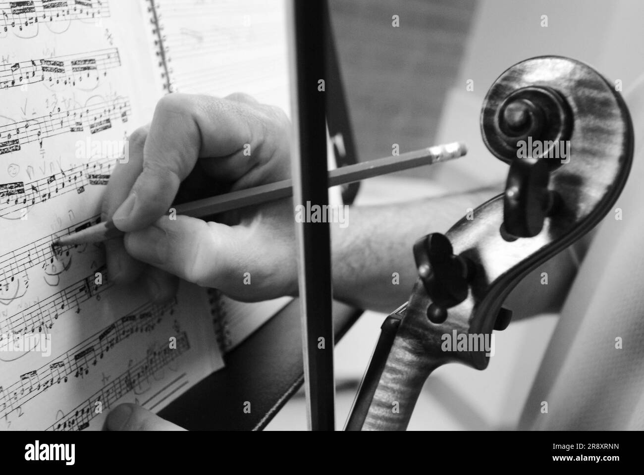 Der Violinist passt die Komposition während des Spiels mit dem Bleistift an. Stockfoto