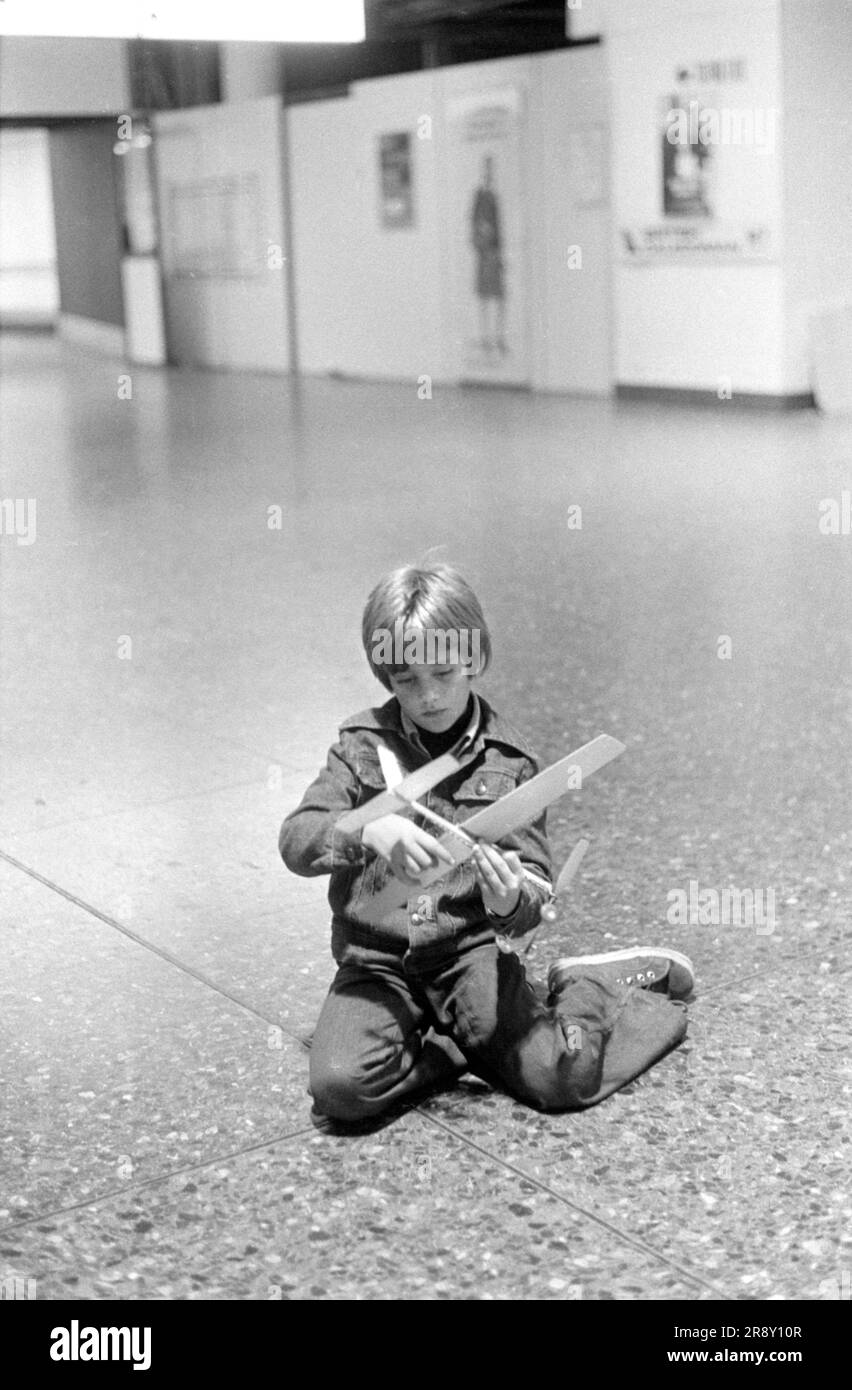 Junge spielt allein mit einem Modellflugzeug in der Abfluglounge des Flughafens Gatwick. Er wartet auf den ersten Skytrain-Flug, der am 26. September 1977 unter großem Hype stattfand. Dies war ein preisgünstiger, preiswerter Service zwischen London Gatwick und JFK in New York. HOMER SYKES AUS DEN 1970ER JAHREN Stockfoto