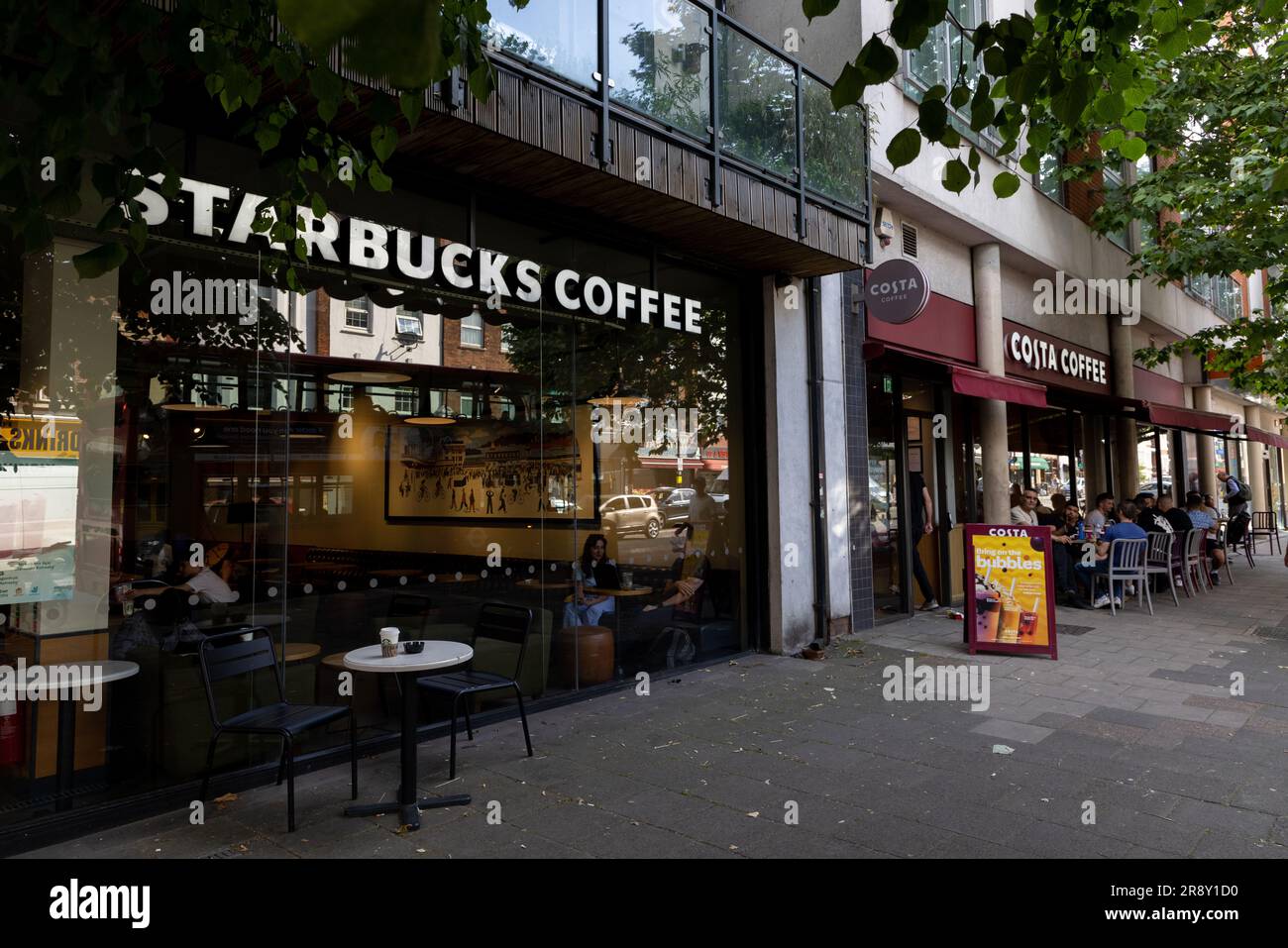 Costa und Starbucks Coffee Shops nebeneinander an einer London High Street: Uxbridge Road, Ealing Common Stockfoto